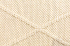 Close-up of the Colombo Cream Rug highlighting its intricate texture and luxurious weave, emphasizing the quality of the New Zealand wool and the braided diamond design.