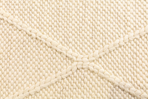 Close-up of the Colombo Cream Rug highlighting its intricate texture and luxurious weave, emphasizing the quality of the New Zealand wool and the braided diamond design.