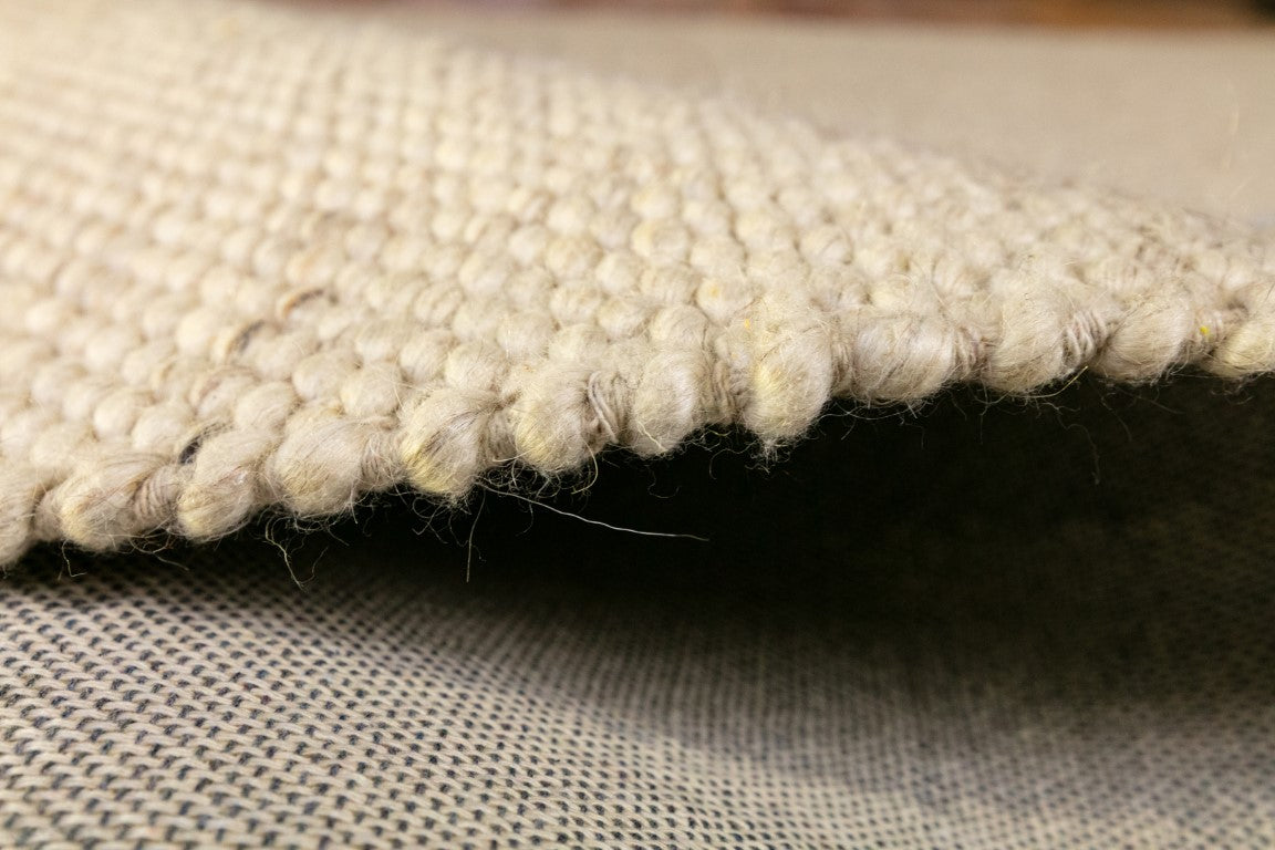 Stylish corner of a room featuring the Park Lane Rug in Pearl, demonstrating its role as a statement piece in home decor with its tight weave and sophisticated design.